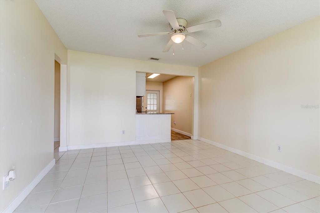 A room with light-colored tile flooring, beige walls, and a ceiling fan — 232 NORTHSHORE DRIVE UNIT A, ORMOND BEACH, FL