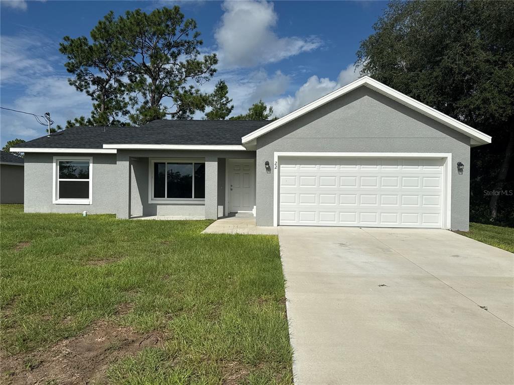 A single-story gray house with a white garage door and a concrete driveway — 22 MALAUKA CIRCLE, OCKLAWAHA, FL