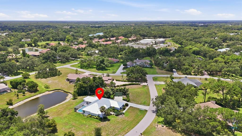 A white house with blue shutters and a metal roof features a landscaped front walkway — 4575 SATINLEAF LANE, SARASOTA, FL