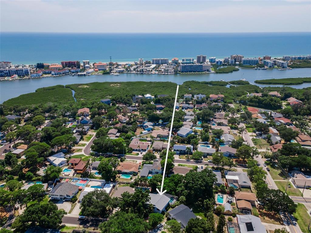 An aerial view shows a residential neighborhood with a house highlighted by a white arrow — 14279 85TH AVENUE, SEMINOLE, FL