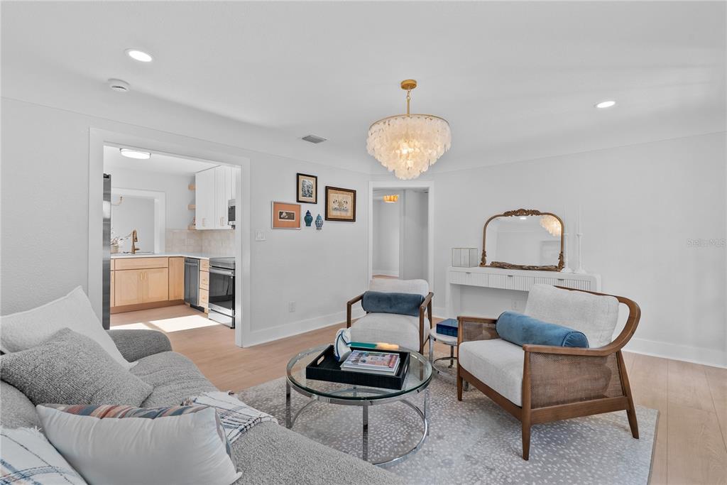 A living room features a gray sofa, two armchairs, a glass coffee table, and chandelier — 1211 16TH AVENUE N, ST PETERSBURG, FL