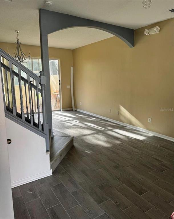 A living area features gray wood-look tile flooring, a staircase, and an arched wall opening — 1289 S BEACH CIRCLE, KISSIMMEE, FL
