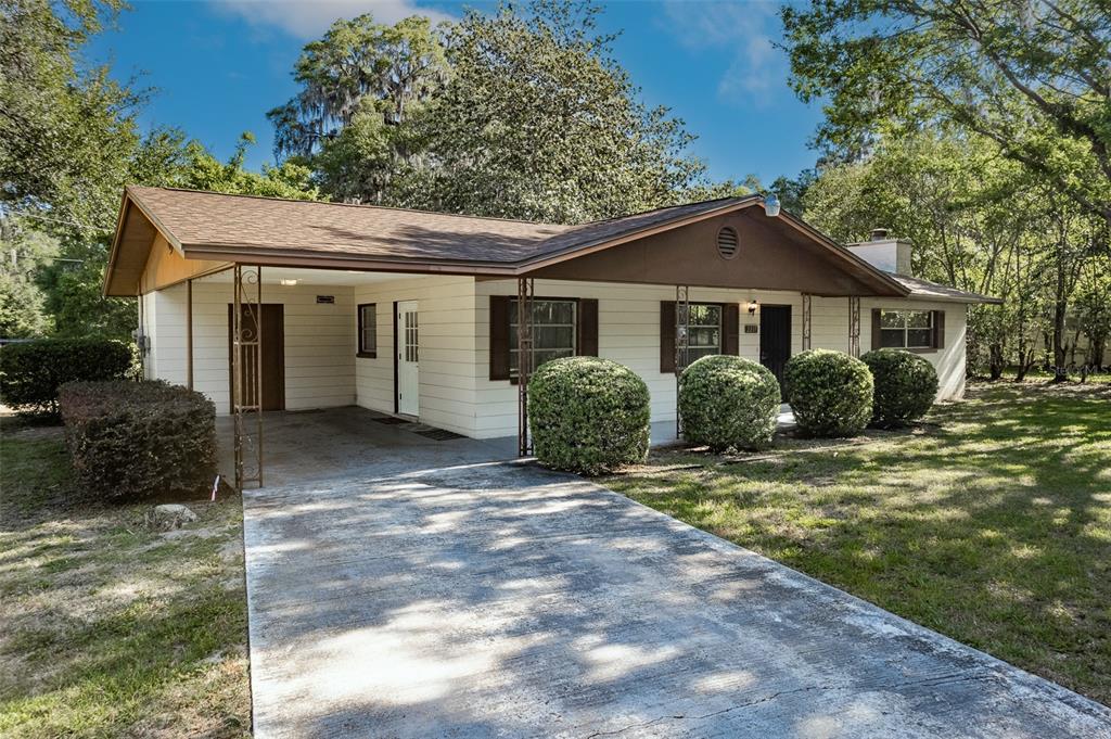A single-story house with a carport, light-colored siding, and a brown roof — 2217 NW 52 STREET, OCALA, FL