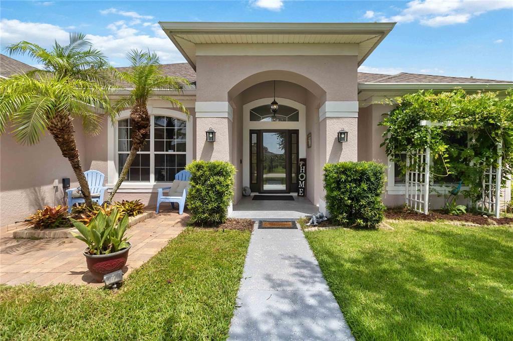 The exterior of a house features a covered entryway, a walkway, and a landscaped yard — 3014 SAND STONE CIRCLE, ST CLOUD, FL