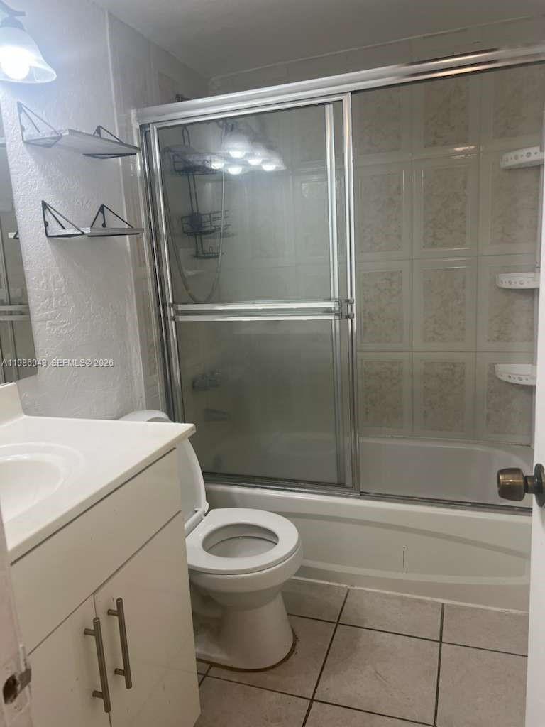 A bathroom features a white vanity, a toilet, and a shower-tub combination with sliding doors — 4550 NW 9th St # 114E, Miami FL 33126, MIAMI, FL