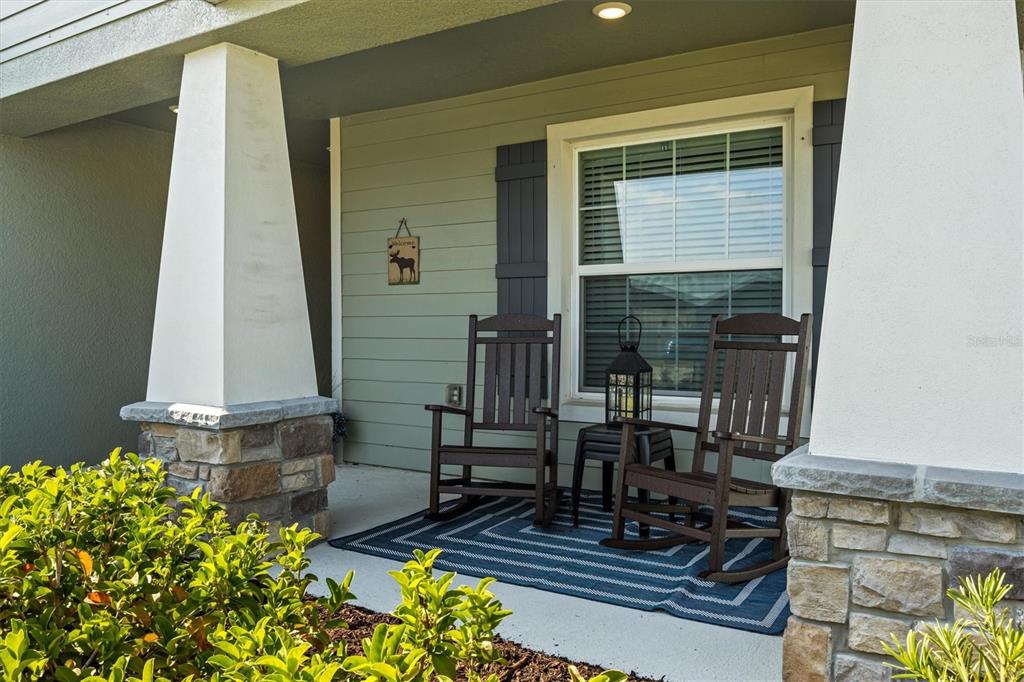 A front porch features two dark wooden rocking chairs on a blue patterned rug — 2008 NOBLE DRIVE, DAVENPORT, FL