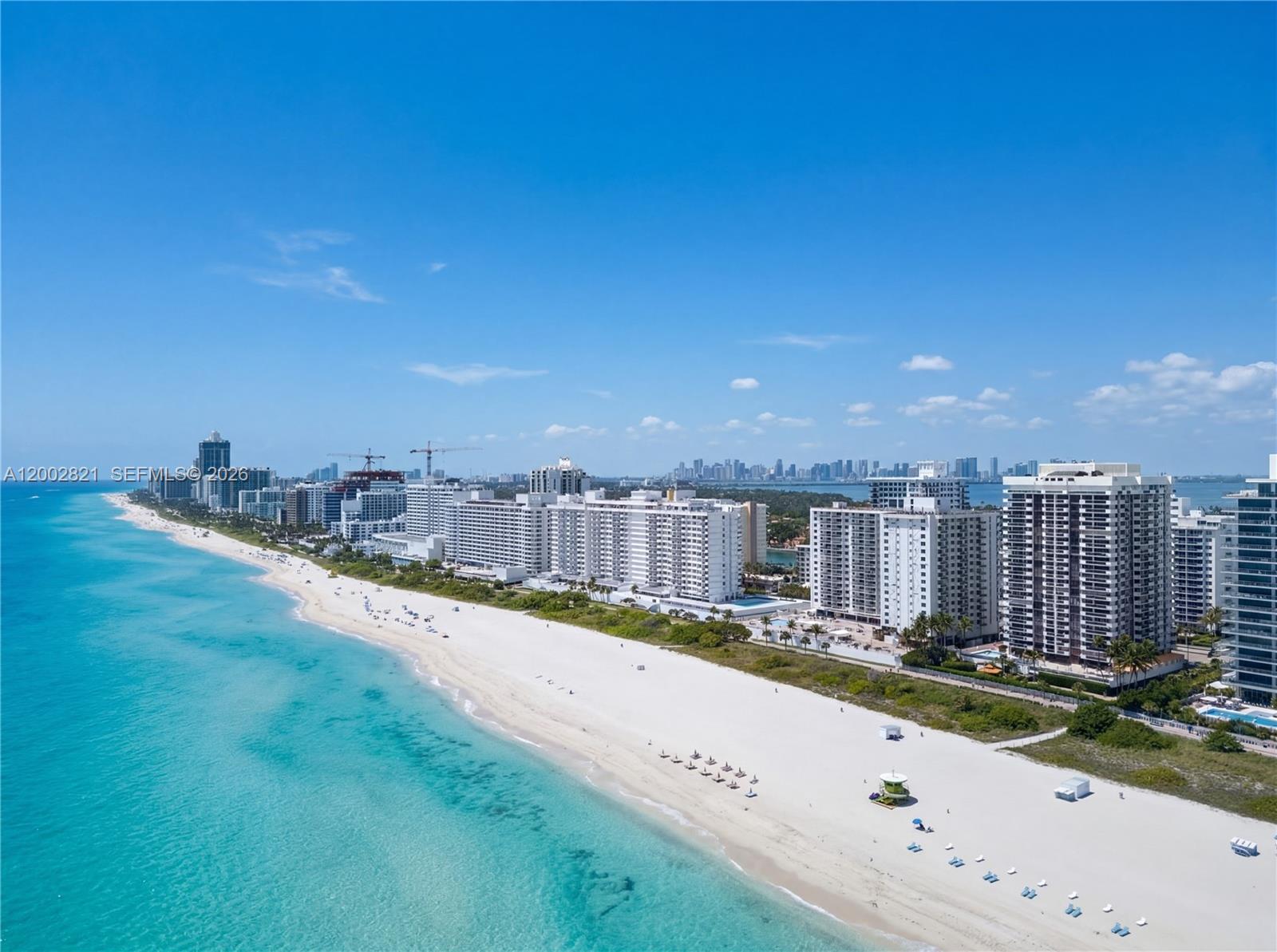 An aerial view shows a sandy beach along the oceanfront with several high-rise buildings — 5757 Collins Ave # 1104, Miami Beach FL 33140, MIAMI BEACH, FL