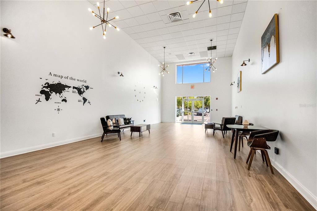 A spacious lobby features wood-look flooring, a world map wall decal, and modern light fixtures — 3390 KORI ROAD, JACKSONVILLE, FL