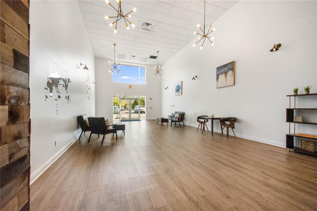 A bright, high-ceilinged lobby features wood-look flooring, modern light fixtures, and a world map mural — 3390 KORI ROAD, JACKSONVILLE, FL