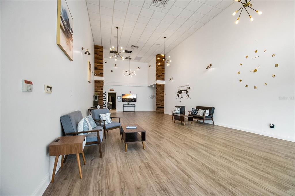 A spacious waiting room features light wood flooring, high ceilings, modern light fixtures, and wall decor — 3390 KORI ROAD, JACKSONVILLE, FL