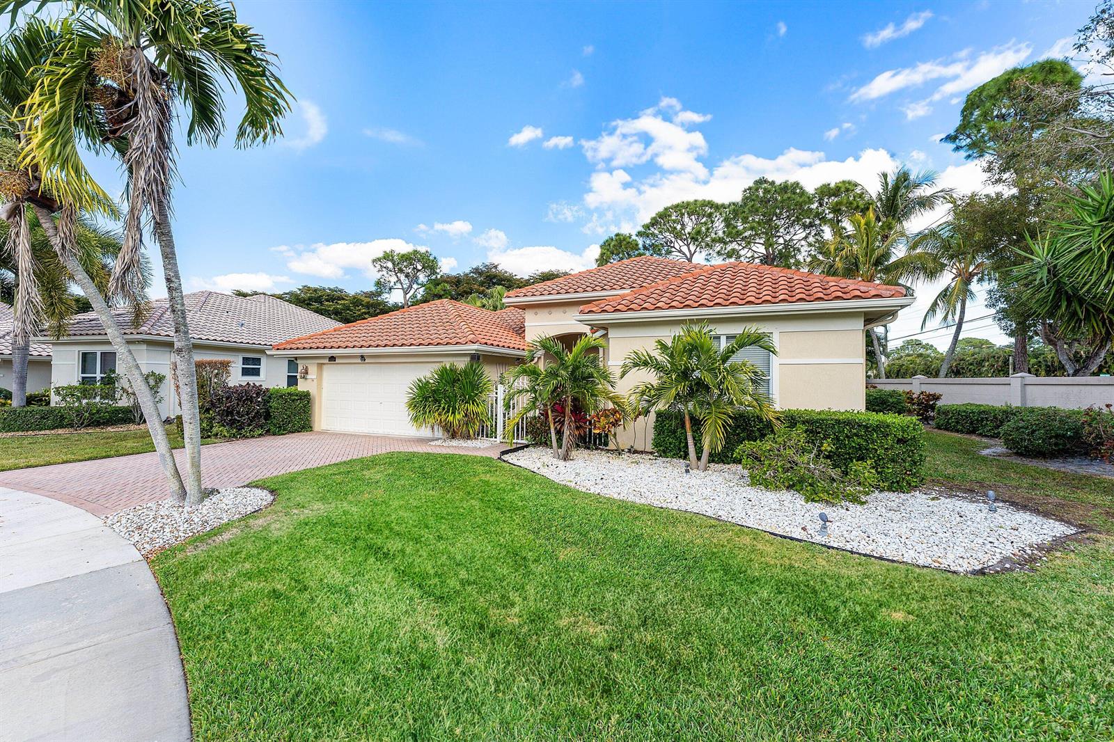 A single-story house with a tile roof, two-car garage, and landscaped yard with palm trees — 6529 Jog Estates Lane, Boynton Beach FL 33437, BOYNTON BEACH, FL