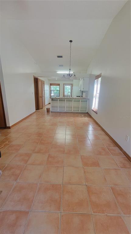 A kitchen with a breakfast bar and tile flooring is visible from an open living area — 1011 LOVE LANE UNIT 31, APOPKA, FL