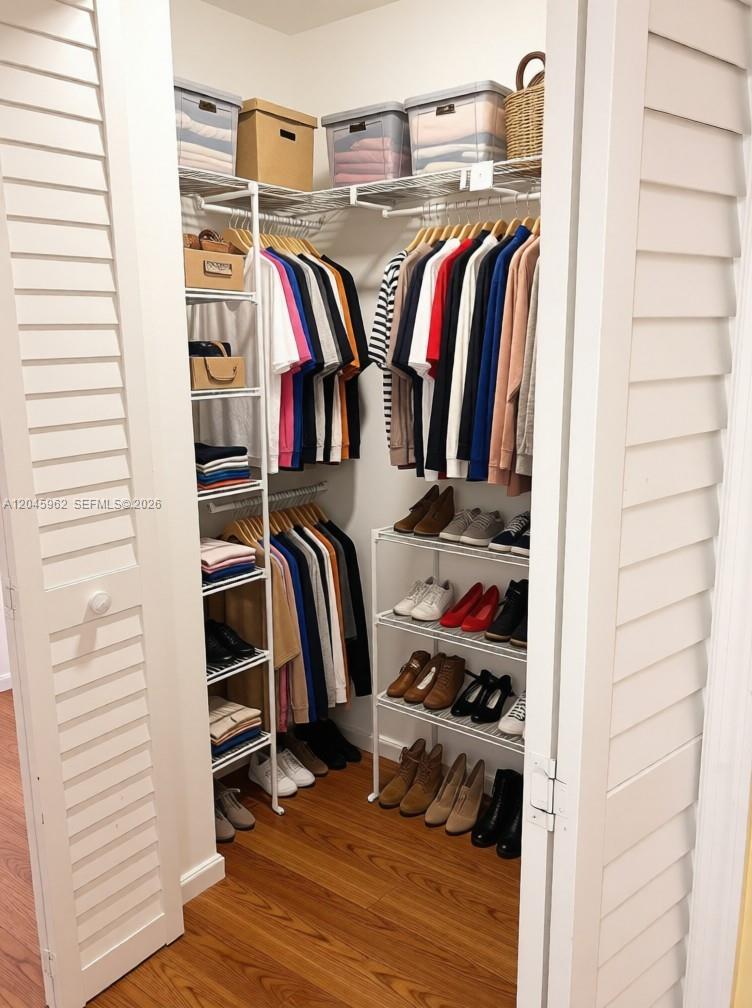 A walk-in closet features white wire shelving, hanging clothes, and organized shoe racks — 1750 W 46th St # 0, Hialeah FL 33012, HIALEAH, FL