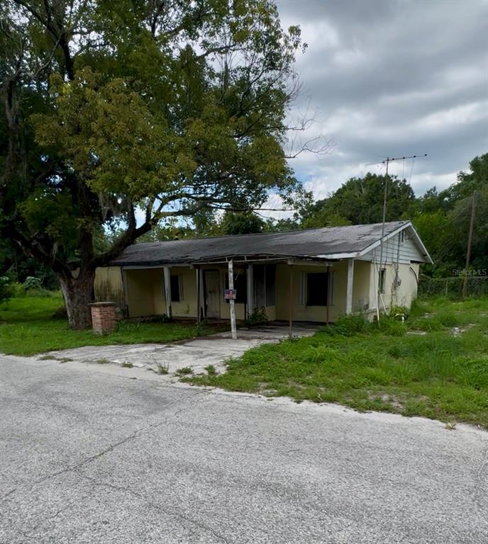 A weathered, single-story house with a front porch sits on a grassy lot — 131 E BAY BOULEVARD S, LAKE WALES, FL