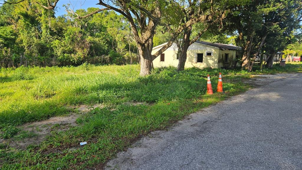A small, weathered house sits on a grassy lot next to a paved road — 131 E BAY BOULEVARD S, LAKE WALES, FL