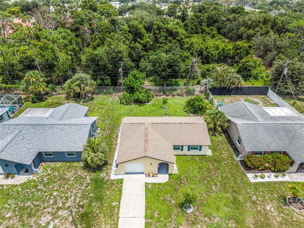 An aerial view shows a single-story house with a driveway, lawn, and surrounding trees — 1032 ELAINE STREET, VENICE, FL