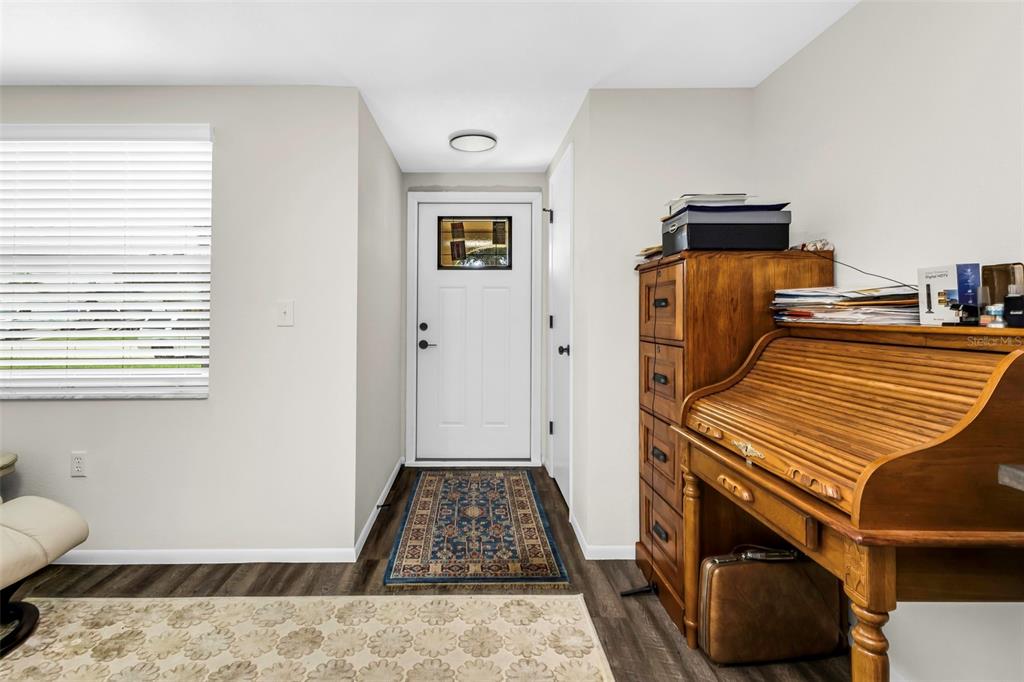 An entryway features a white front door, wood-look flooring, and a wooden roll-top desk — 1032 ELAINE STREET, VENICE, FL