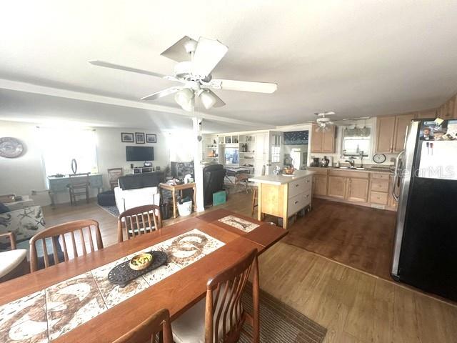 An open-concept kitchen and dining area features wood flooring, a ceiling fan, and cabinetry — 4906 SEA ISLAND AVENUE, SARASOTA, FL