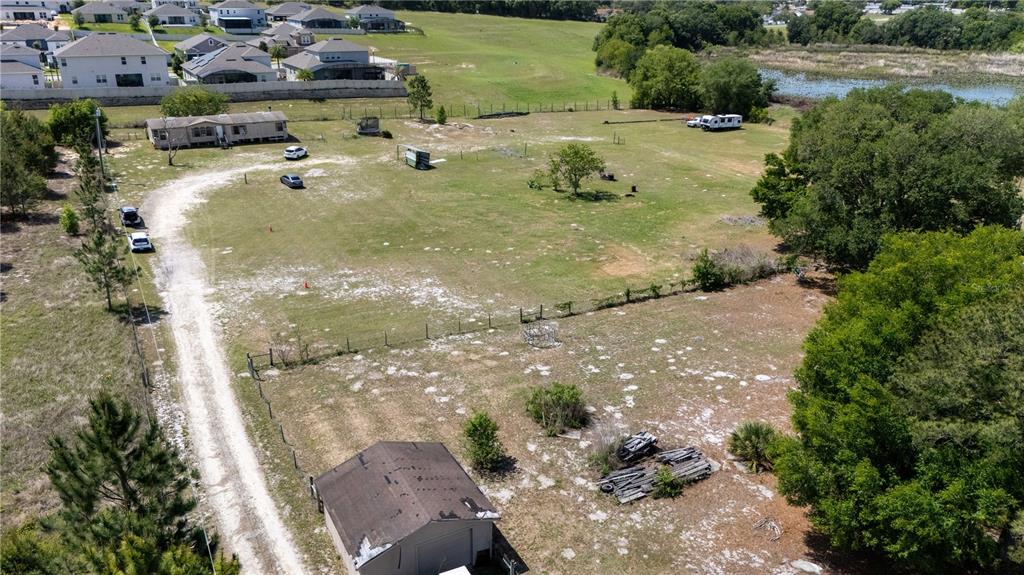 An aerial view shows a large grassy lot with a house, shed, and driveway — 12606 S GRASSY LAKE ROAD, MINNEOLA, FL