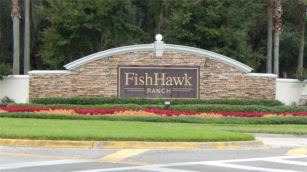 A stone monument sign for FishHawk Ranch sits behind a landscaped bed and green lawn — 5925 SANDHILL RIDGE DRIVE, LITHIA, FL