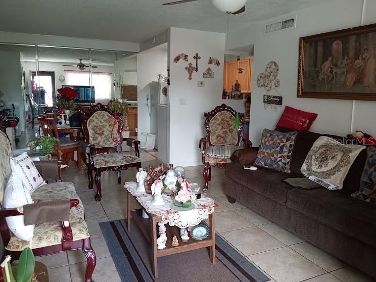 A living room features a brown sofa, two ornate wooden chairs, and a central coffee table — 933 W OAK RIDGE ROAD UNIT 933 B, ORLANDO, FL