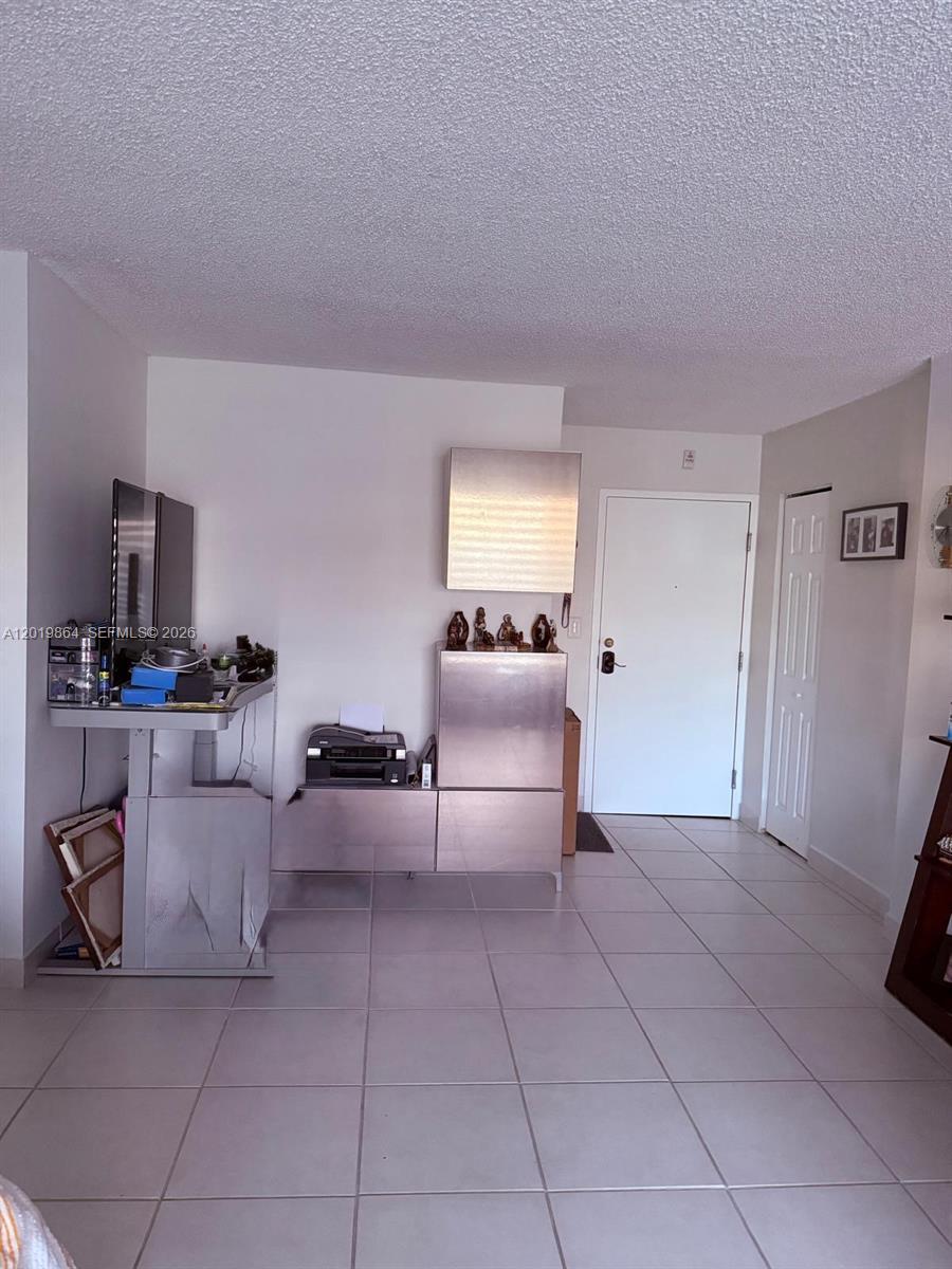 A room with white walls, tiled floors, a standing desk, and a metal storage unit — 1250 NE 125th St # 317A, North Miami FL 33161, NORTH MIAMI, FL