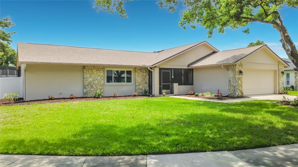 A single-story house with a beige exterior, stone accents, and a two-car garage — 8654 ALEGRE CIRCLE, ORLANDO, FL