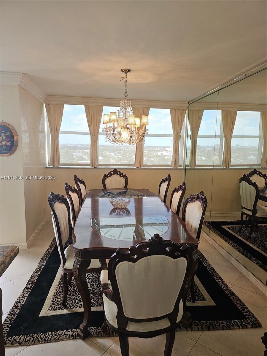 A formal dining room features a wooden table, eight chairs, a chandelier, and mirrored walls — 2049 S Ocean Dr, Hallandale Beach FL 33009, HALLANDALE BEACH, FL