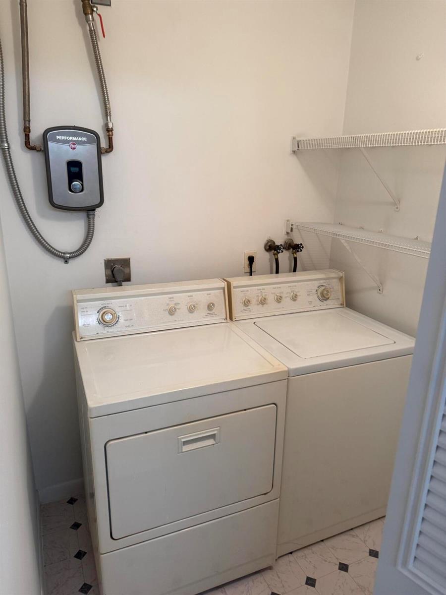 A laundry closet contains a white washer and dryer with a wall-mounted water heater above — 5795 La Pinata Boulevard # 2, FL 33463, FL