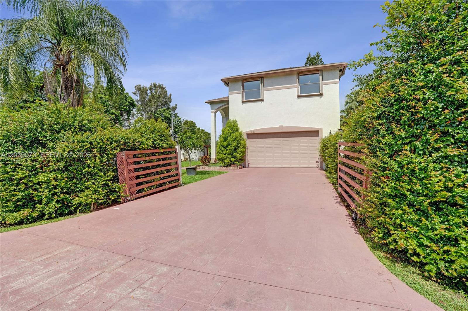 A two-story house features a paved driveway, a two-car garage, and surrounding privacy hedges — 2151 NW 121st Ave, Plantation FL 33323, PLANTATION, FL
