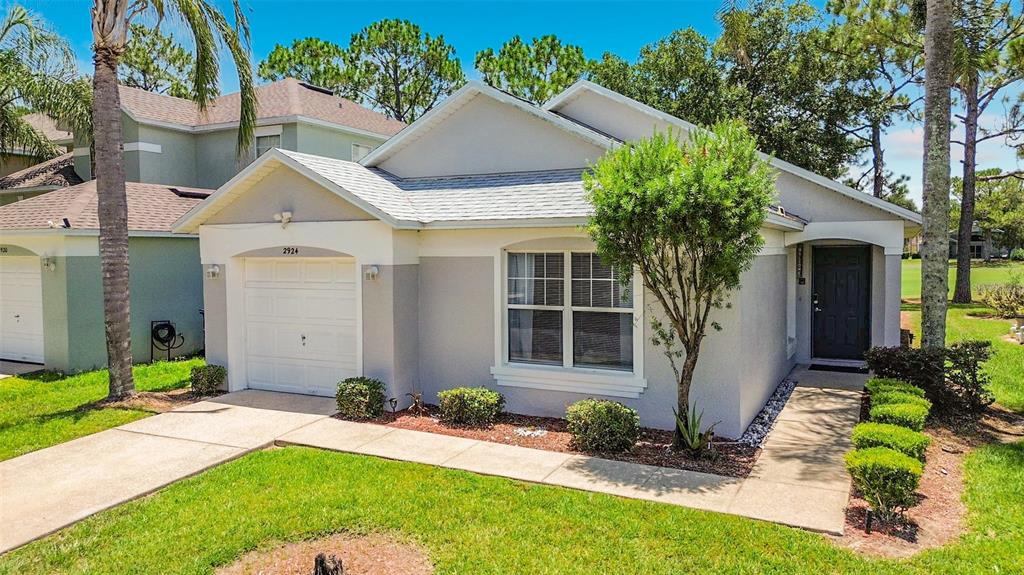 A single-story house with a white garage, grey siding, and a front walkway — 2924 KOKOMO LOOP, HAINES CITY, FL