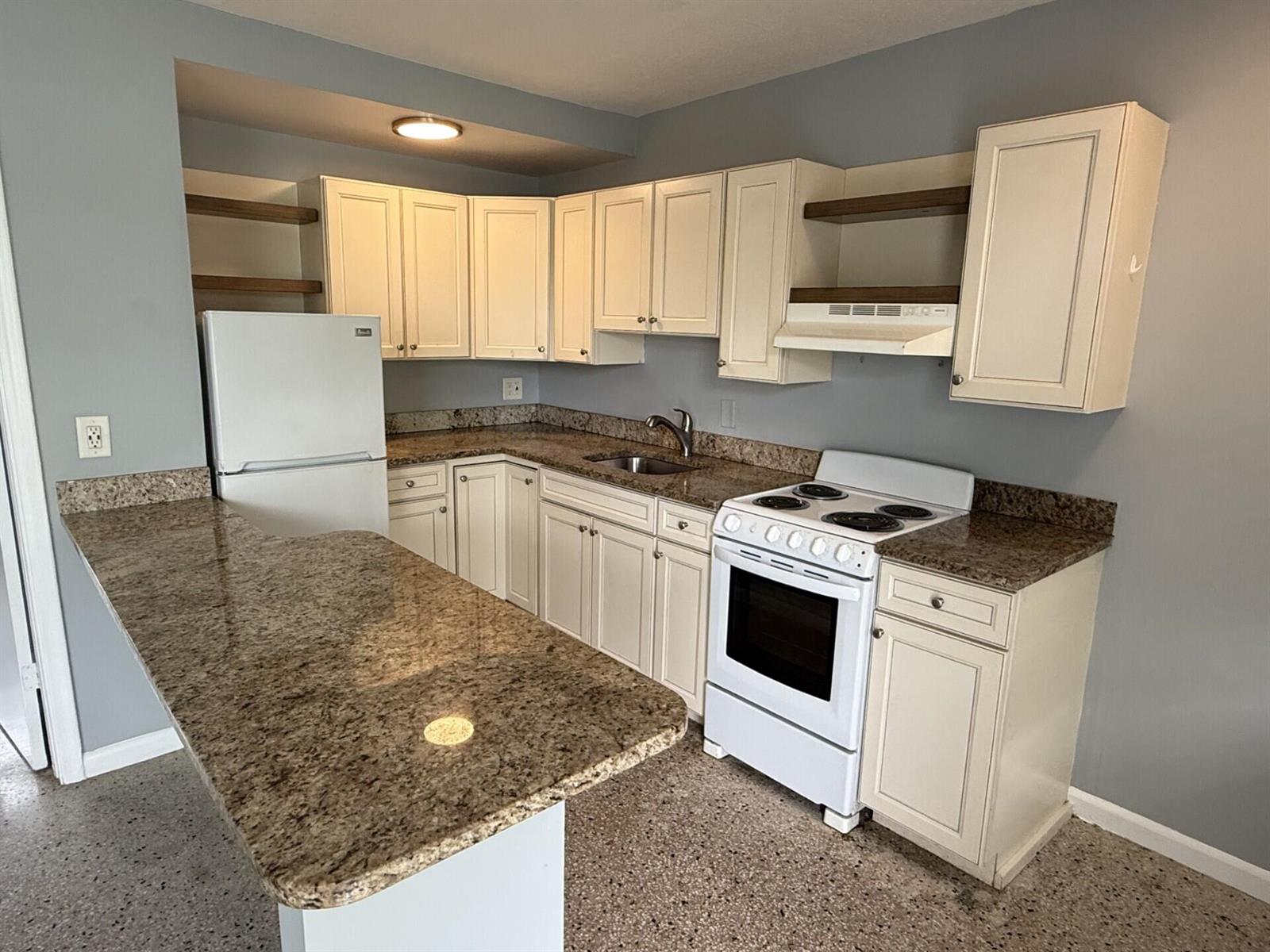 A kitchen features white cabinets, granite countertops, a white refrigerator, and a white electric stove — 1118 N H Street # 15, FL 33460, FL