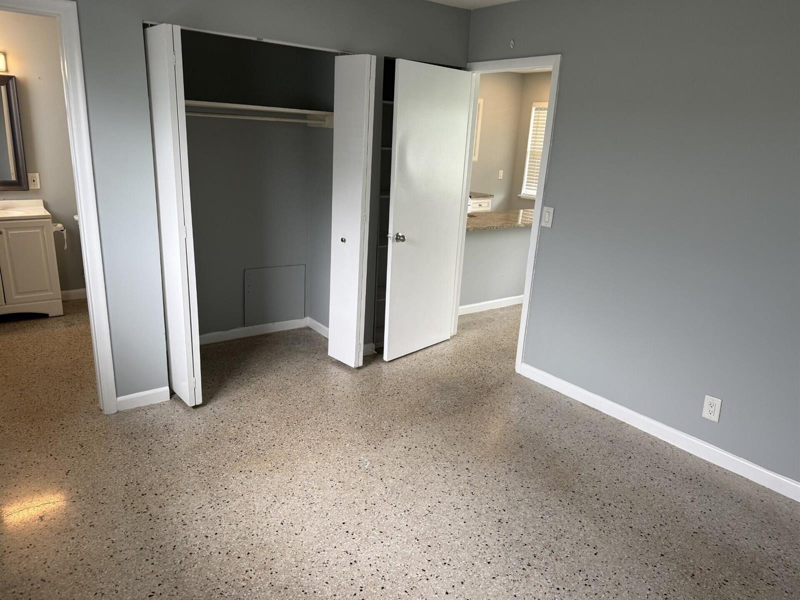 A room with gray walls, terrazzo flooring, a closet, and a doorway leading to a kitchen — 1118 N H Street # 15, FL 33460, FL