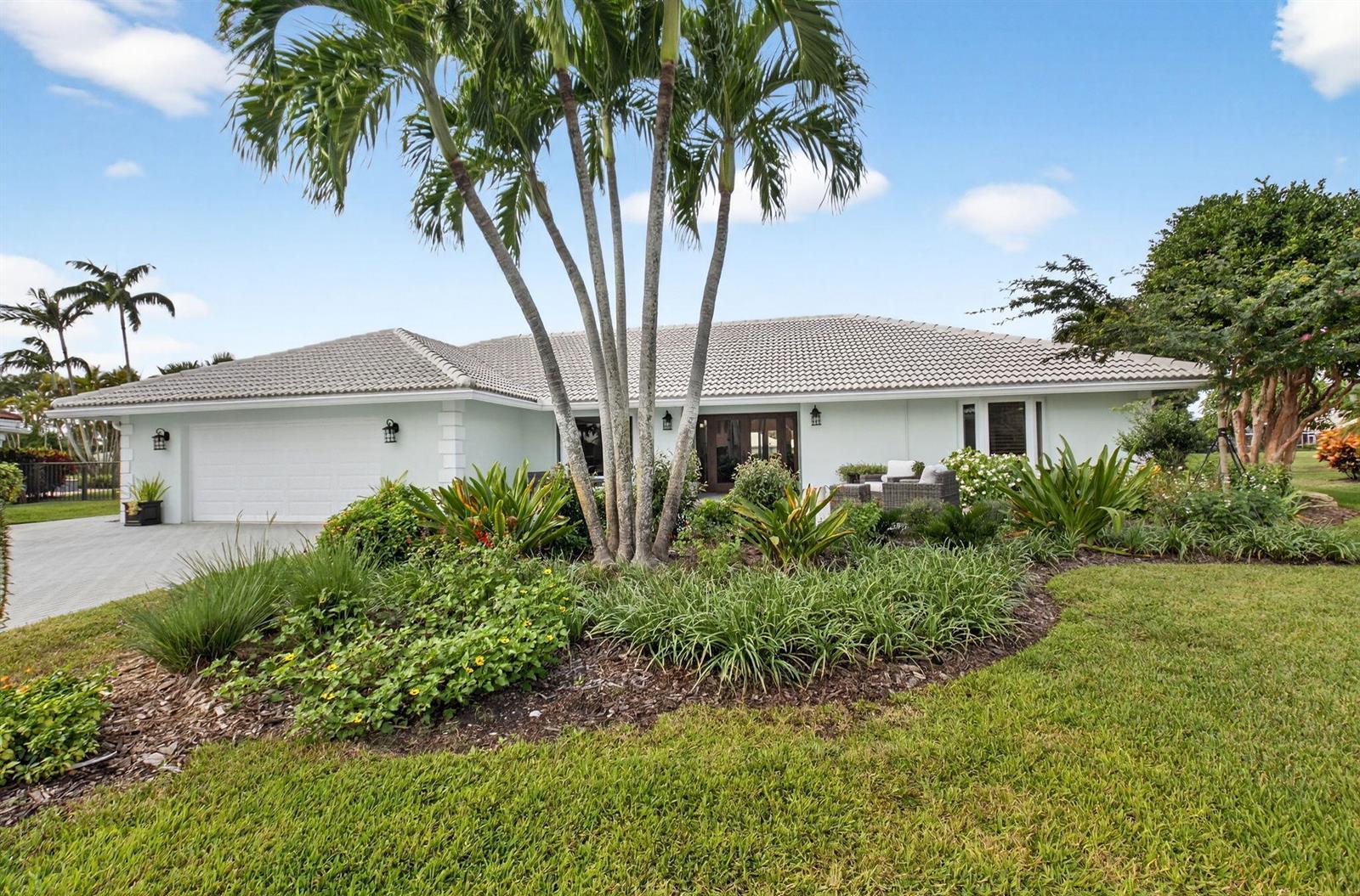 A single-story house with a white garage, tiled roof, and palm trees in the front yard — 11949 Date Palm Drive, Boynton Beach FL 33436, BOYNTON BEACH, FL