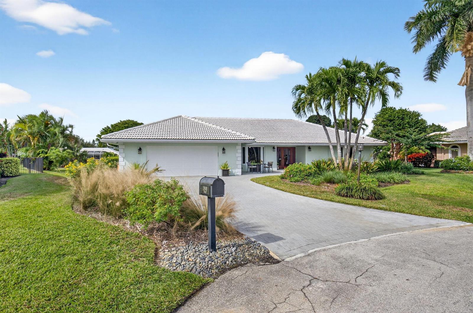 A single-story house with a light-colored exterior, tiled roof, and a paved driveway — 11949 Date Palm Drive, Boynton Beach FL 33436, BOYNTON BEACH, FL