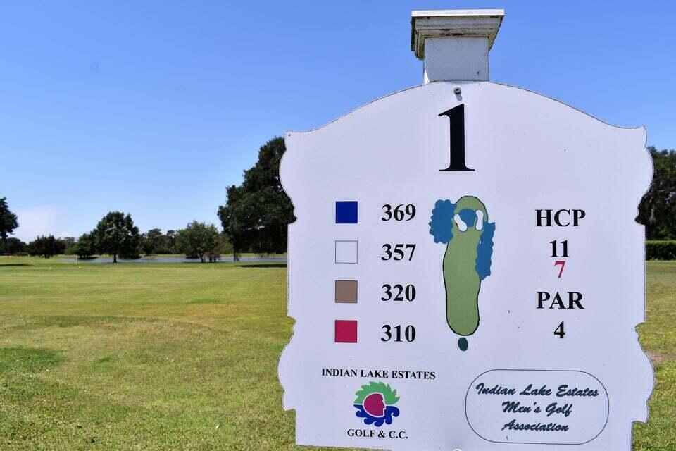 A golf course tee box sign displays the hole number, distances, par, and handicap information — 405 Pandora Drive, FL 33855, FL