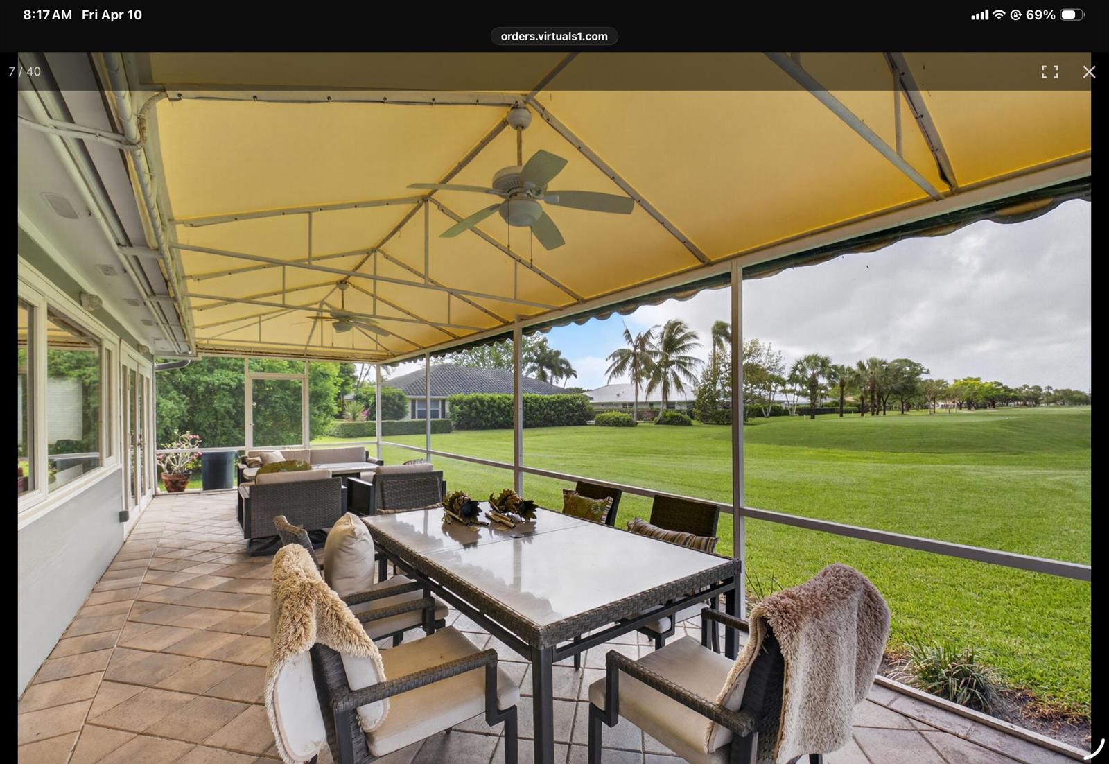 A covered patio with a dining set and lounge furniture overlooks a large grassy lawn — 2 Holly Drive, Boynton Beach FL 33436, BOYNTON BEACH, FL