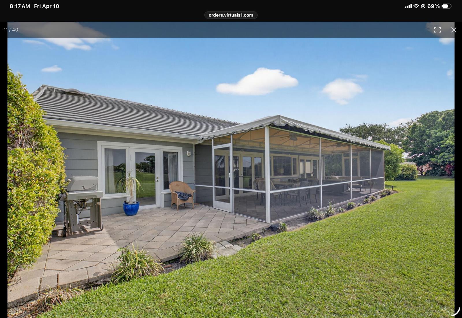 A gray house features a paved patio, a gas grill, and a large screened-in porch — 2 Holly Drive, Boynton Beach FL 33436, BOYNTON BEACH, FL
