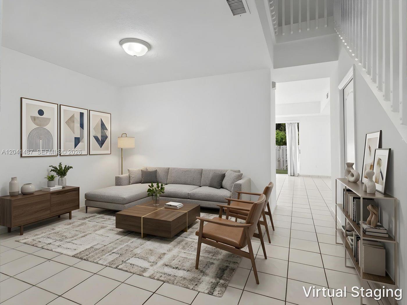 This virtually staged living room features a gray sectional, wooden coffee table, and tile flooring — 10966 NW 43rd Ter # 10966, Doral FL 33178, DORAL, FL