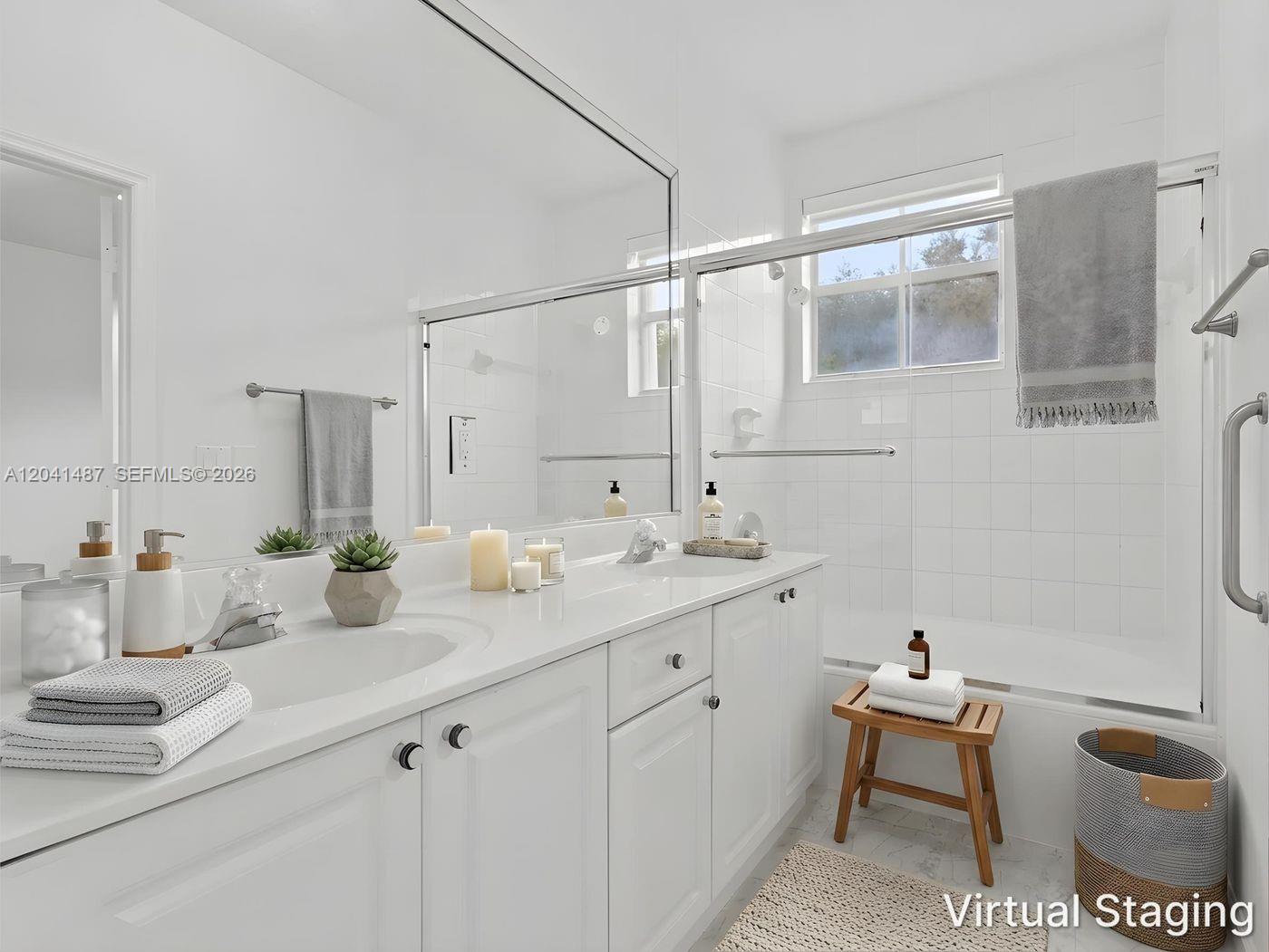 A bright bathroom features a white vanity, a large mirror, and a tiled shower area — 10966 NW 43rd Ter # 10966, Doral FL 33178, DORAL, FL