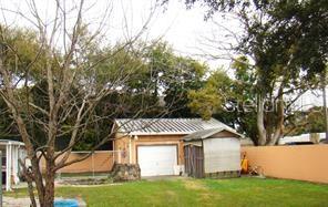 A detached garage with a white door and a small shed sits in a backyard — 414 W OAK RIDGE ROAD, ORLANDO, FL