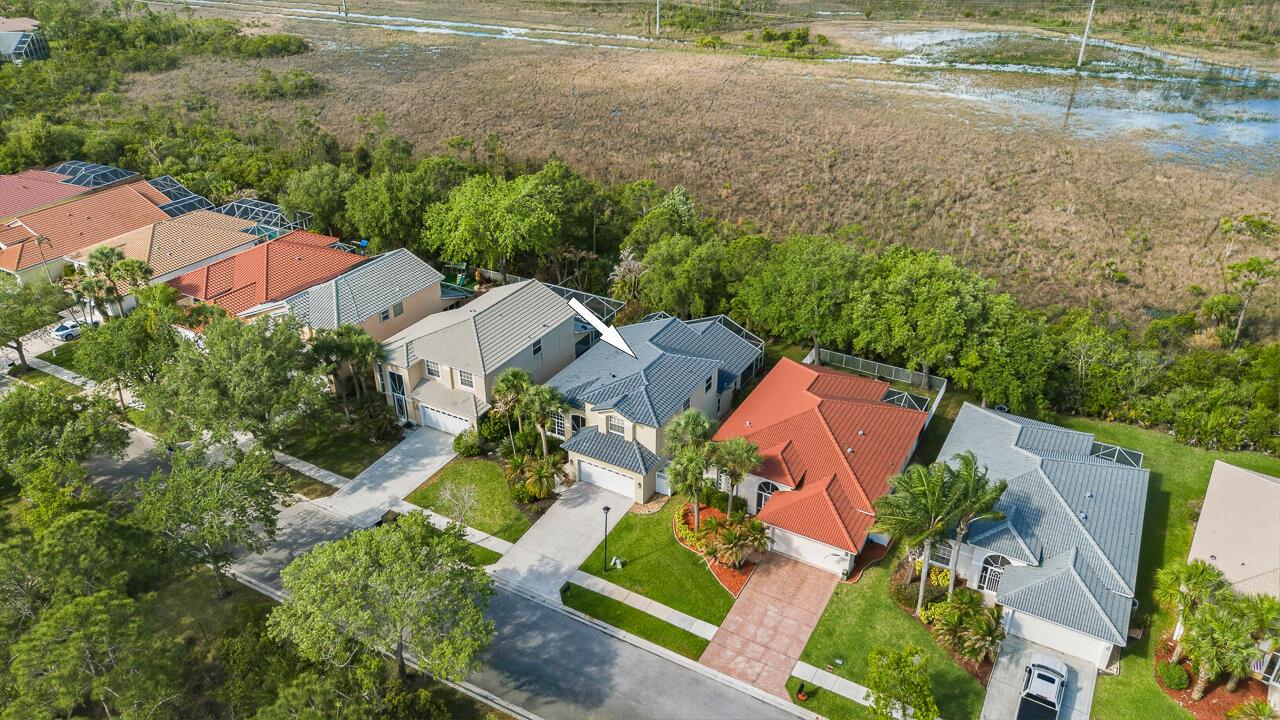 An aerial view of a suburban street featuring several houses with tiled roofs and backyards — 7213 SE Magellan Lane, Stuart FL 34997, STUART, FL