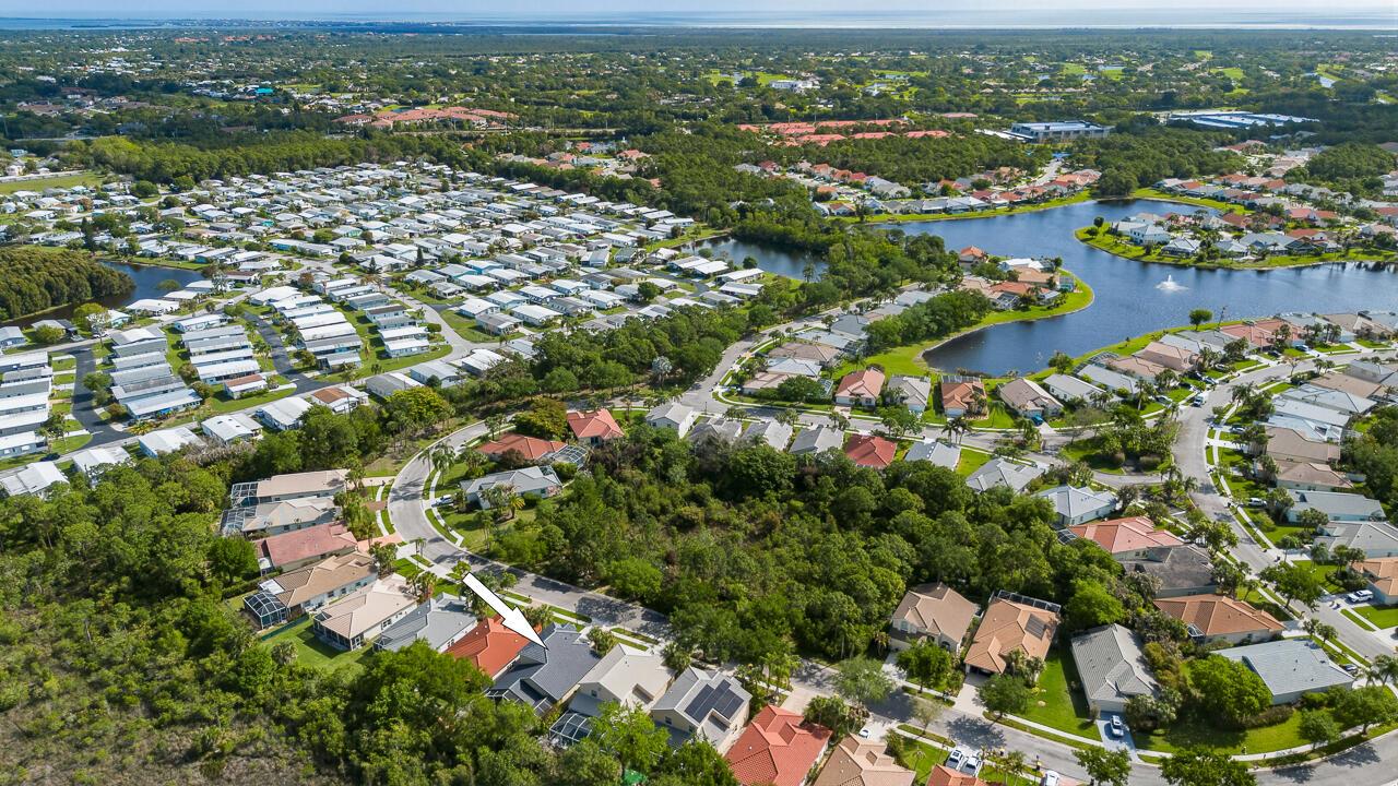 An aerial view shows a residential neighborhood with a house highlighted by a white arrow — 7213 SE Magellan Lane, Stuart FL 34997, STUART, FL