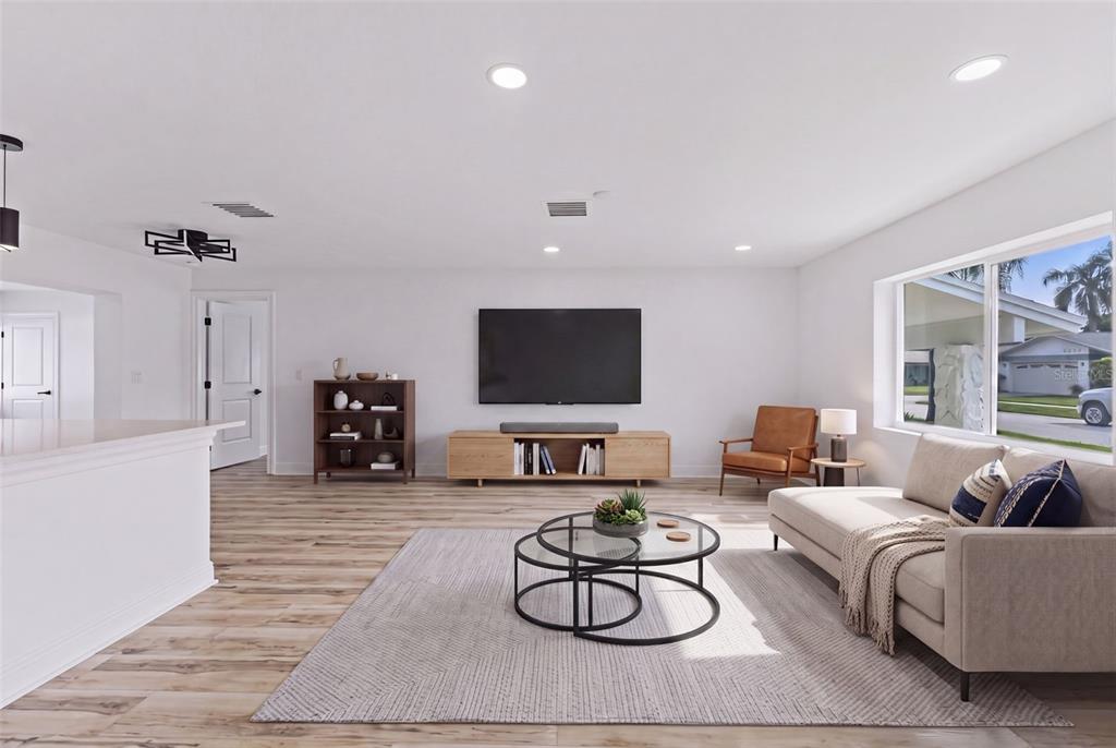 A living room features light wood flooring, a mounted television, a sofa, and a rug — 9354 119TH WAY, SEMINOLE, FL