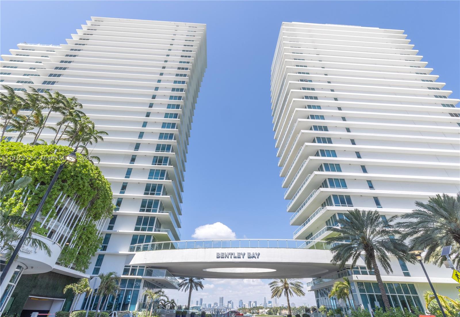 The exterior view shows two tall, white residential towers connected by a bridge structure — 520 West Ave # 1102, Miami Beach FL 33139, MIAMI BEACH, FL