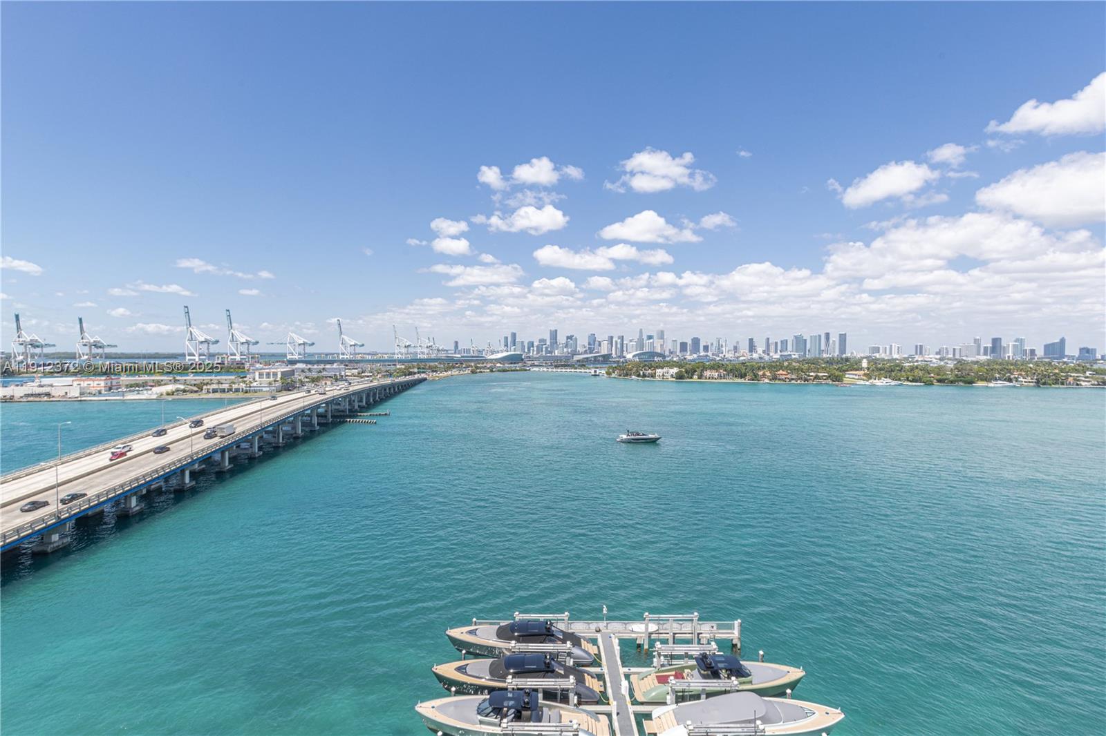 An elevated view of a bridge, a marina with docked boats, and the Miami skyline — 520 West Ave # 1102, Miami Beach FL 33139, MIAMI BEACH, FL