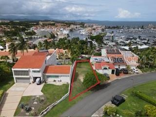 An aerial view shows a vacant, triangular-shaped lot situated between two residential houses — HARBOUR VIEW UNIT 10, HUMACAO, PR