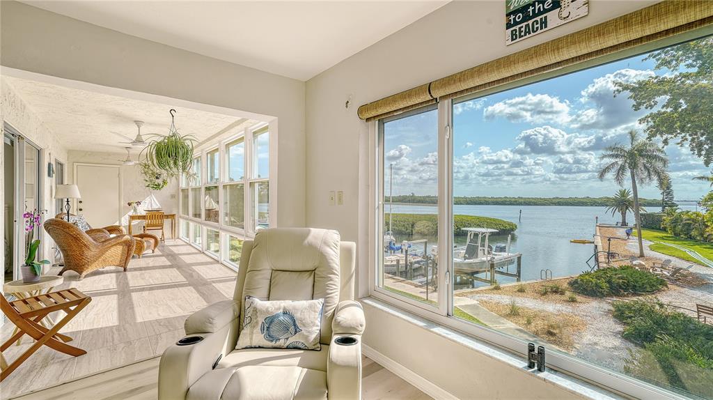 A view from a hallway looking into a living room and a sunroom with water views — 4500 GULF OF MEXICO DRIVE UNIT 206, LONGBOAT KEY, FL