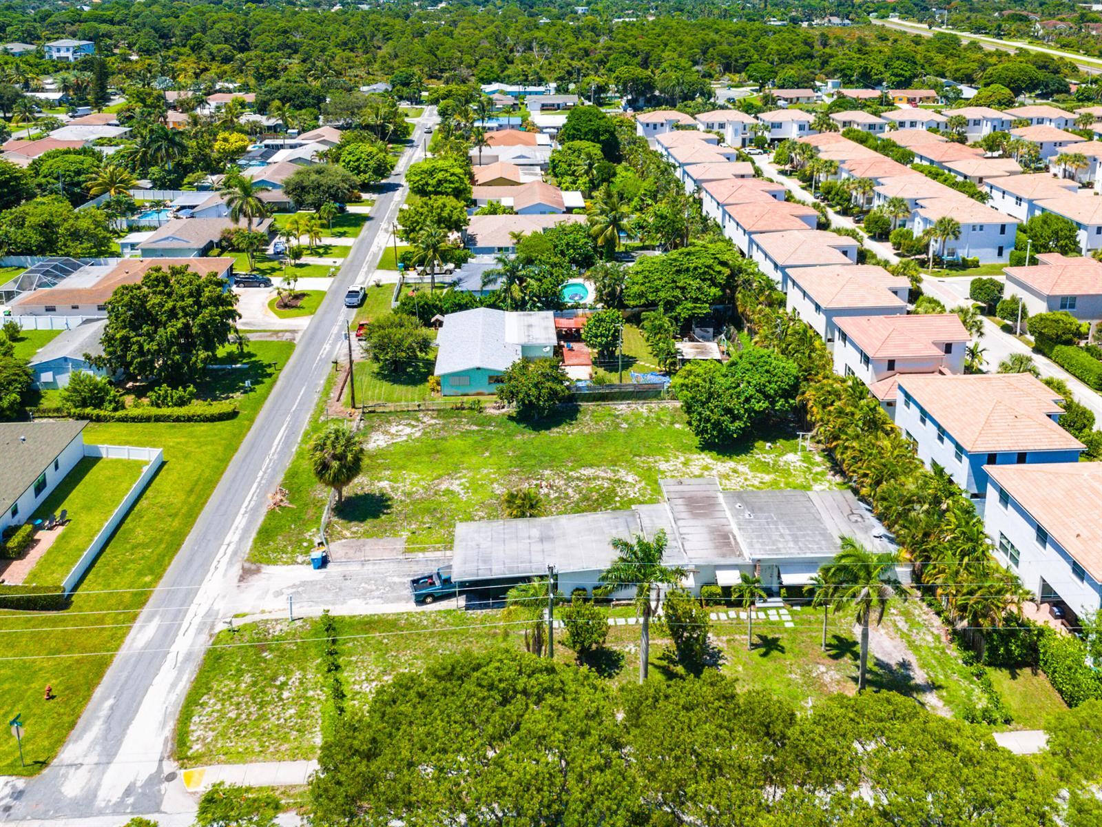 An aerial view shows a residential neighborhood with houses, palm trees, and a vacant lot — 335 Gulfstream Boulevard, Boynton Beach FL 33435, BOYNTON BEACH, FL