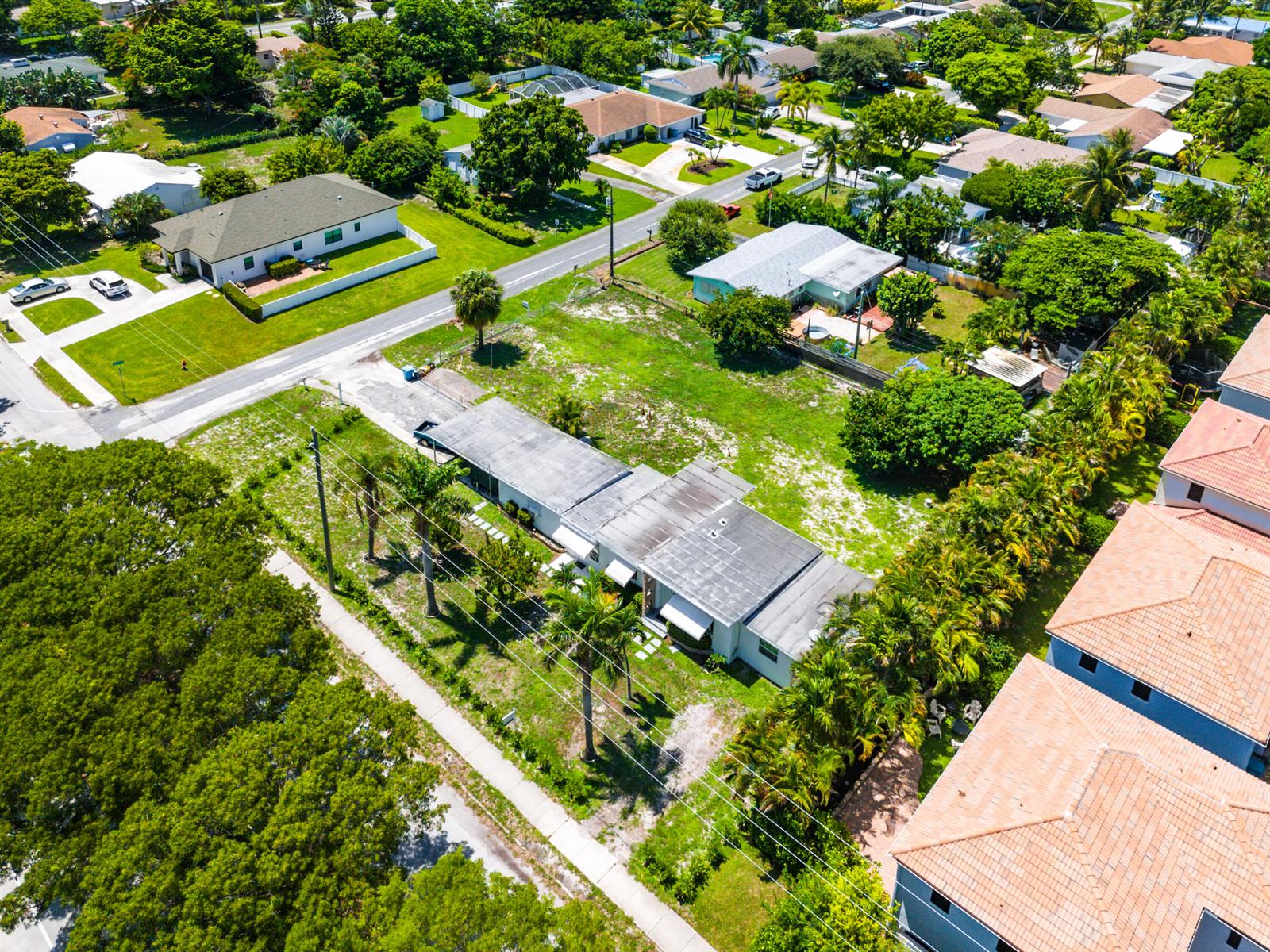 An aerial view shows a single-story house with a flat roof surrounded by green lawns — 335 Gulfstream Boulevard, Boynton Beach FL 33435, BOYNTON BEACH, FL